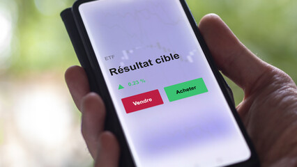 Un investisseur analyse un fonds etf résultat cible sur un graphique. Un téléphone affiche le cours de l'ETF. Texte en français francais Résultat cible