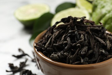 Dry bergamot tea leaves in bowl, closeup. Space for text