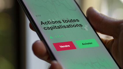Un investisseur analyse un fonds etf actions toutes capitalisations sur un graphique. Un téléphone affiche le cours de l'ETF. Texte en français francais Actions toutes capitalisations