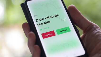 Un investisseur analyse un fonds etf date cible de retraite sur un graphique ETF target-date, fonds à horizon. Un téléphone affiche le cours de l'ETF. Texte en français francais.