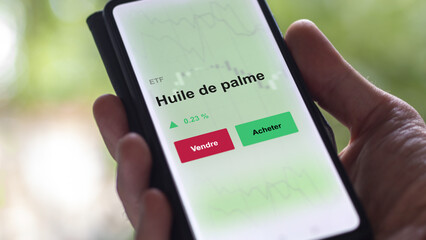 Un investisseur analyse un fonds etf huile de palme sur un graphique. Un téléphone affiche le cours de l'ETF. Texte en français francais huile de palme