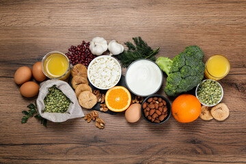 Set of natural food high in calcium on wooden table, flat lay