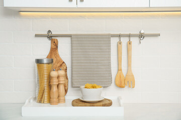 Clean towel, utensils and uncooked pasta in kitchen