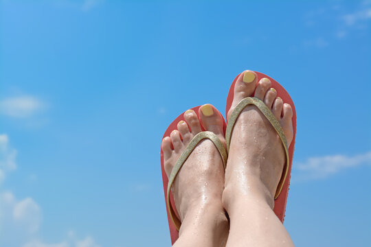 Woman in stylish pink flip flops against blue sky, closeup of feet. Space for text