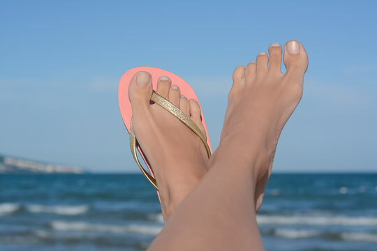 Woman wearing stylish flip flop near sea, closeup