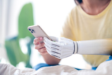 Girl disability bionic arm using phone, reading social media and chatting in bed, disabled cyborg...