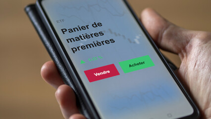 Un investisseur analyse un fonds etf panier de matières premières sur un graphique. Un téléphone affiche le cours de l'ETF. Texte en français francais Panier de matières premières