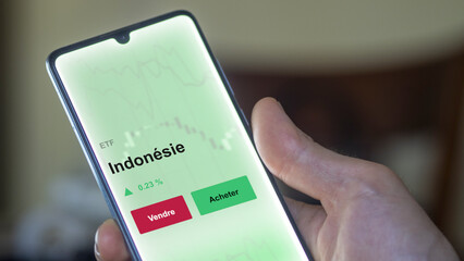 Un investisseur analyse un fonds etf indonésie sur un graphique. Un téléphone affiche le cours de l'ETF. Texte en français francais Indonésie