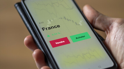 Investir dans un ETF FRANCE. Un téléphone affiche le cours de l'ETF. Texte en FRANÇAIS, France