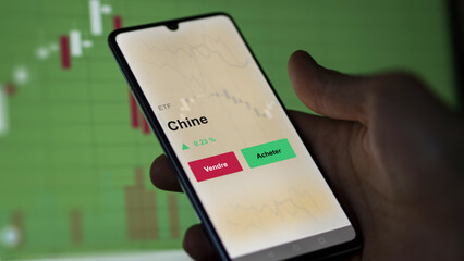 Un investisseur analyse un fonds etf chine sur un graphique. Un téléphone affiche le cours de l'ETF. Texte en français francais Chine