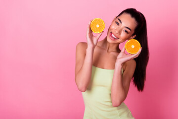 Photo of cunning pretty woman wear yellow dress holding citrus halves empty space isolated pink...