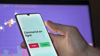 Un investisseur analyse un fonds etf commerce en ligne sur un graphique. Un téléphone affiche le cours de l'ETF. Texte en français francais Commerce en ligne