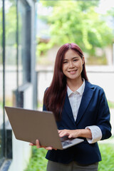 Portrait of a smiling Asian businesswoman holding a computer