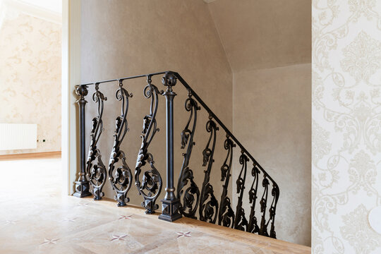 wooden stairs with metal wrought iron railings in a new house