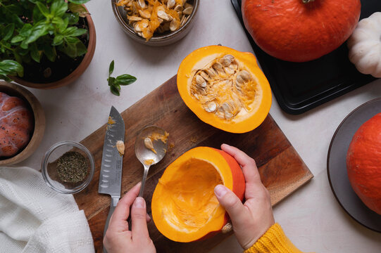 Cooking Pumpkin Food. Female Hands Taking Off Pumpking Seeds. Top View Of Cooking A Squash Or Butternut Soup Or Pie.