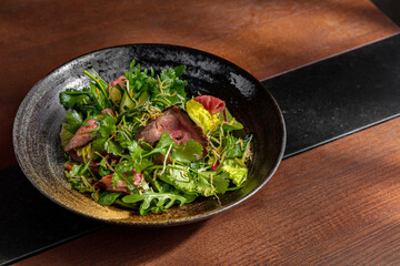 Salad with meat, arugula, frisse salad, cucumber
