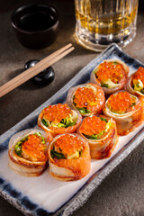 Roll with eel, salmon, red salmon caviar, avocado and salad