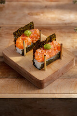 Unwrapped roll with nori, rice, salmon, sauce, tobiko caviar