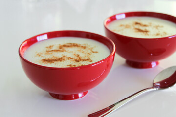 Milky dessert in the bowls, light pudding with cinnnamon powder