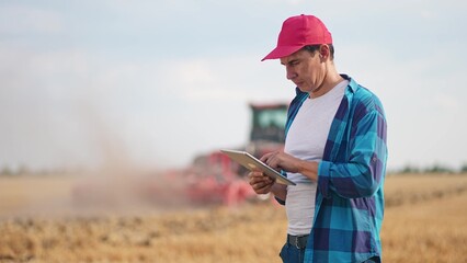 Agriculture. Portrait of a farmer working on a digital tablet in a field in the background a...