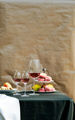 Composition with a glass of pink wine. Ros? wine with peaches on the table.