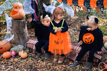 Fototapeta na wymiar happy kids in halloween costumes having fun in halloween decorations outdoor