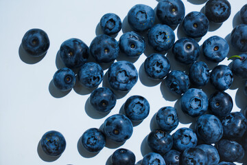 Fresh blueberries on a white background in the daylight, close-up of the delicious berries