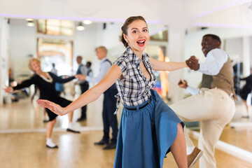 Cheerful female practicing lindy hop in pair with man