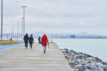 Red coat woman walking with Pink umbrella, TURKEY