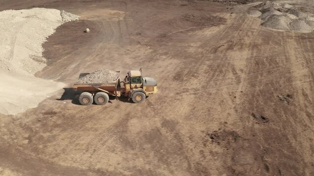 A bird's eye view of a full dump truck traveling on a construction site.