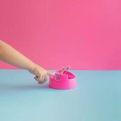 Child's hand pointing to pink potty with fresh flower. Potty training concept.