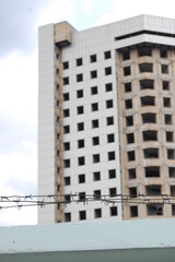 Barbed wire on the background of an unfinished or destroyed house.The concept of safe security in world war for a human rights slave, a hostage in prison, a hope for peace. International liberty day.