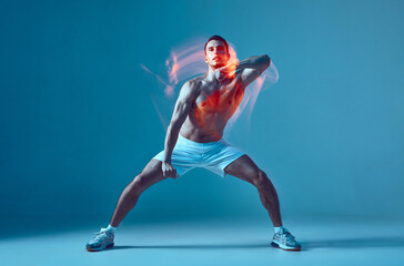 Plakat Dancing athletic sexy young male with naked muscular torso performs contemporary energetic dance. Motion blur
