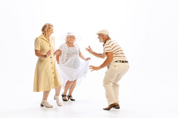 Handsome senior man and two charming women in vintage retro style outfits isolated on white...