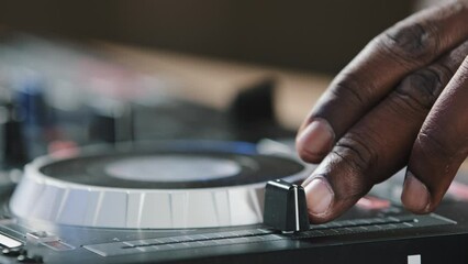 Close-up unrecognizable DJ man African American male finger using mixer controller desk in club switch audio disc turns up volume guy musician in studio play live music disco party touching sliders