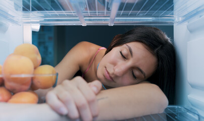 Woman cooling herself in the fridge