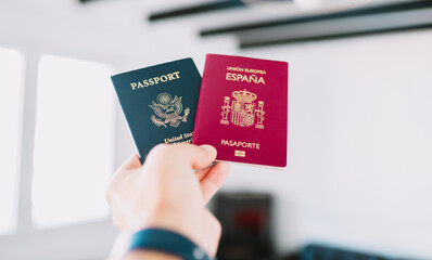 Hand holding a European and American passports.