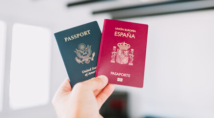 Hand holding a European and American passports.