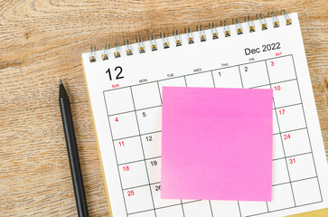 Blank sticky note on December 2022 desk calendar.