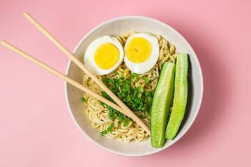 Portion of noodles with a boiled egg on a pink background. Traditional oriental food. instant noodles
