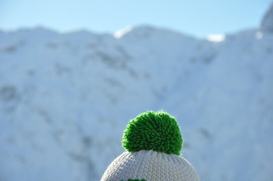 Einsame grüne Pudelmütze im Winterurlaub