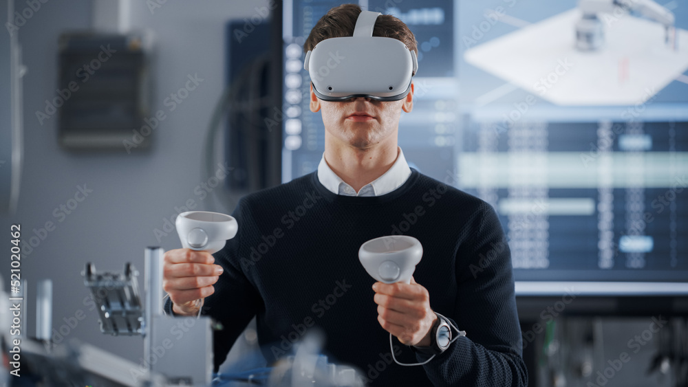 Aufkleber Male Student in VR Goggles Lifting and Moving Bionic Hand With Controllers While Doing His Project at the University of Technology. Computer Science and Robotics Education Concept.