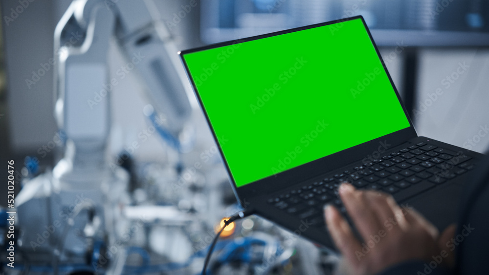 Poster Black Female Engineer Using Laptop with Green Screen Display for Programming Robotic Arm At the Factory. New Generation in Robotics and Automatic Manufacturing Industry Concept.