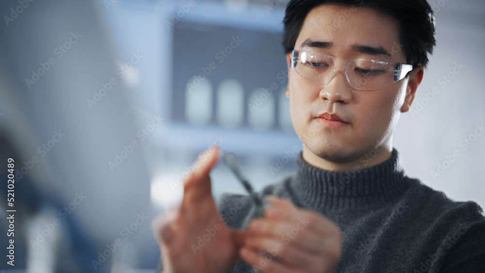 Poster Asian Student Examining Micro Chip and Takes Out Memory Card While Working on Complicated Project in The Laboratory of Modern University. Futuristic Technologies, Science and Development Concept.