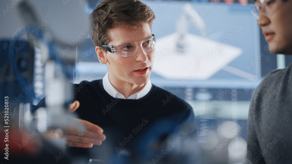Poster asian development engineer student brainstorming with his caucasian classmate in a high tech researc