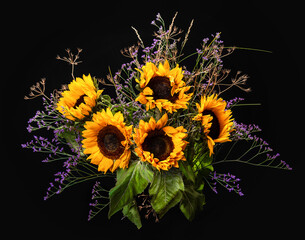 Bouquet of sunflowers and field herbs on a black background