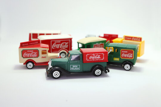 Coke drink. Coca Cola collectible trucks. Toys for children with the soda cola brand. Logo. Beverage transport trucks from different eras. Classic trucks. Merchandising with logo in Spanish. Isolated