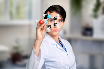 A young scientist looking at a molecular structure model.