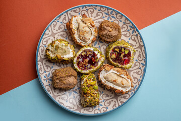 Turkish delight on a plate with oriental ornaments on a colored background. Multicolored organic oriental sweets lokum. Top view of plate and copyspace