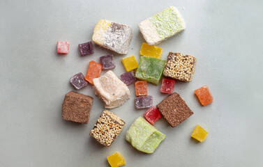 Organic Turkish delight scattered on a gray background. Multicolored lokum candy top view. Set of Turkish delight in different shapes and sizes